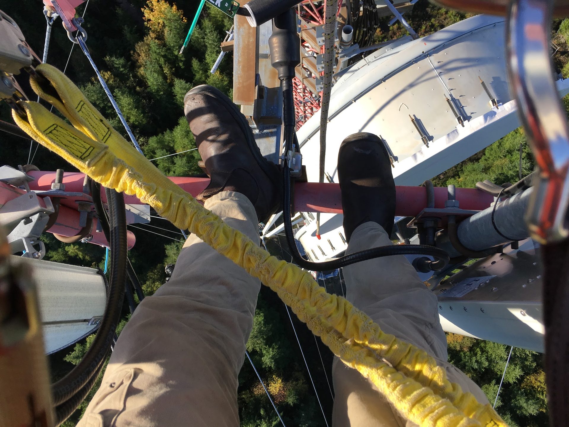 Tower climber's boots and safety lanyard secured on a communications tower