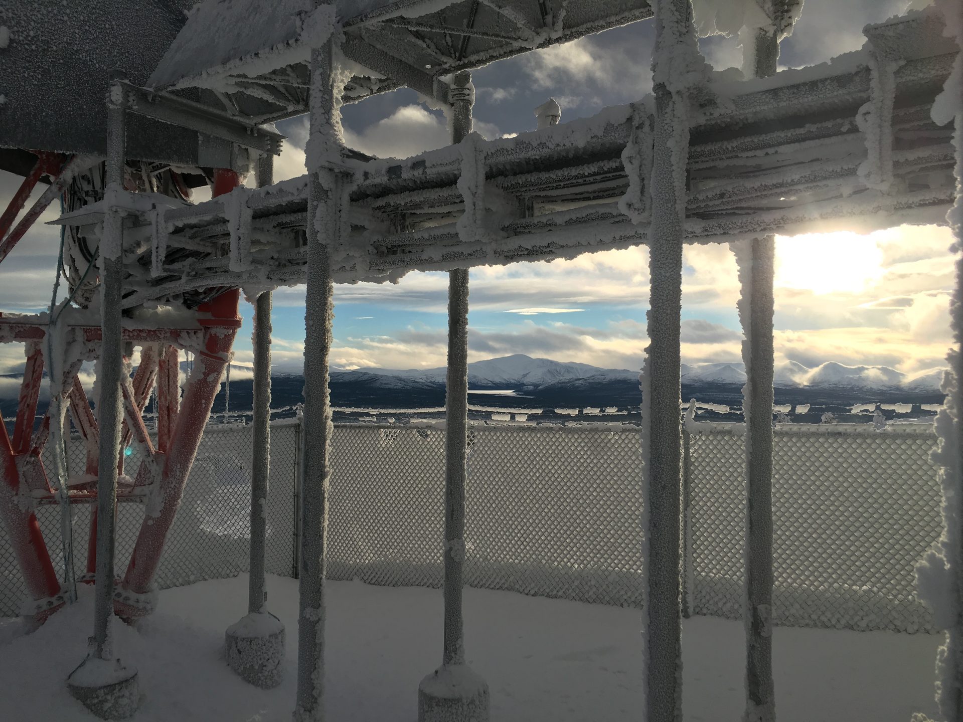 Ice-covered communications tower structure in winter