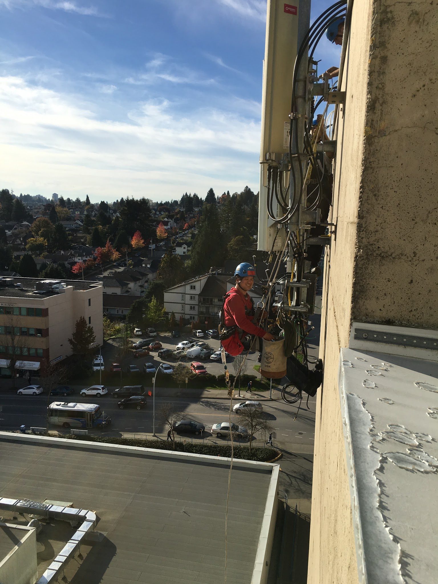 Installer working at height on a rooftop tower mount